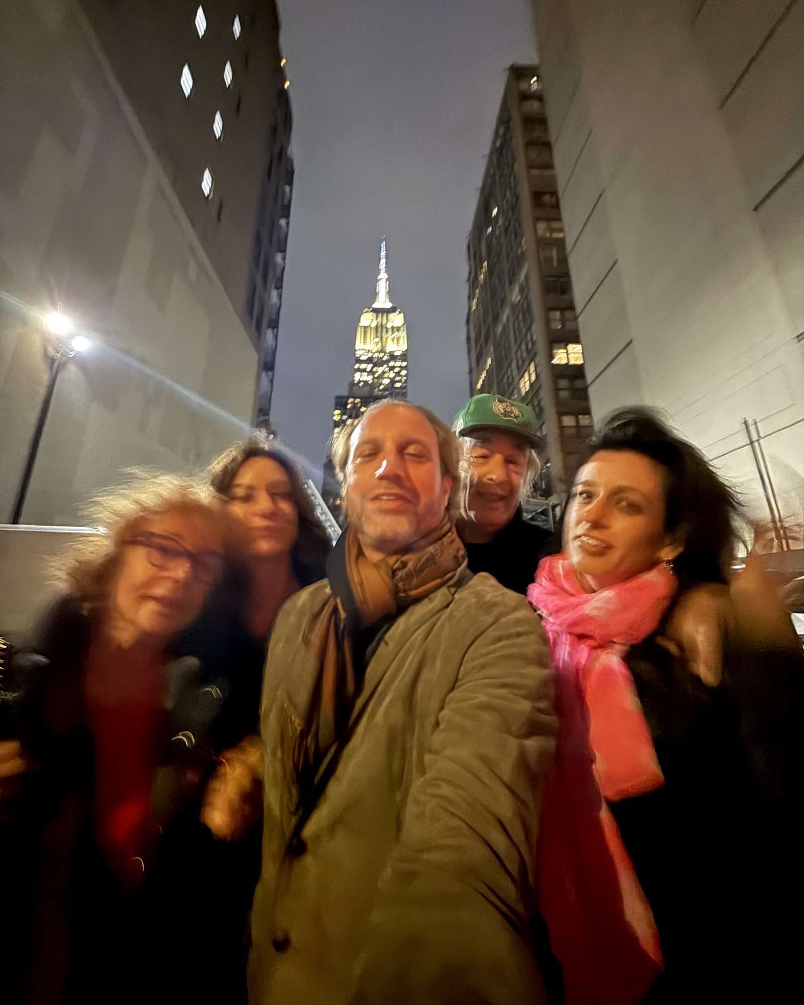 009 everyone in A blurred night time street photograph of five family members, the Empire State Building lit between two buildings behind them.the car has an opinion
